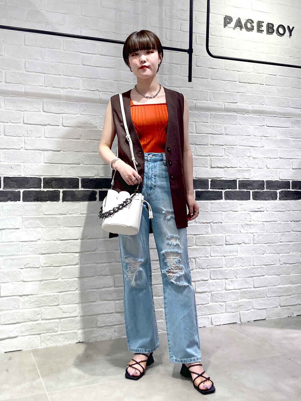 ブラック系のサンダル、ブルー系のデニムパンツ、ブラウン系のその他アウターを着用したレディースの夏コーディネートの2枚目の写真