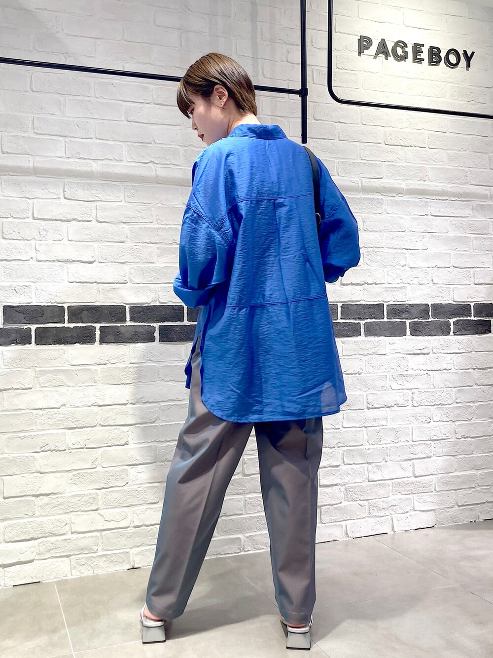 ブラック系のタンクトップ、ブルー系のシャツ/ブラウス、グレー系のスラックスを着用したレディースの夏コーディネートの5枚目の写真