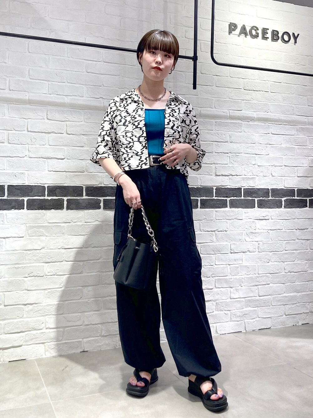 ブラック系のシャツ/ブラウス、グリーン系のタンクトップ、ブラック系のショルダーバッグを着用したレディースの夏コーディネートの2枚目の写真