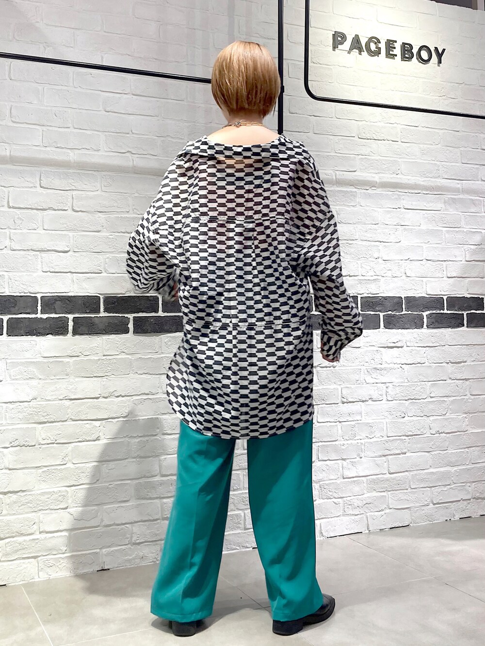 グリーン系のスラックス、ブラック系のシャツ/ブラウス、ピンク系のタンクトップを着用したレディースの春コーディネートの5枚目の写真