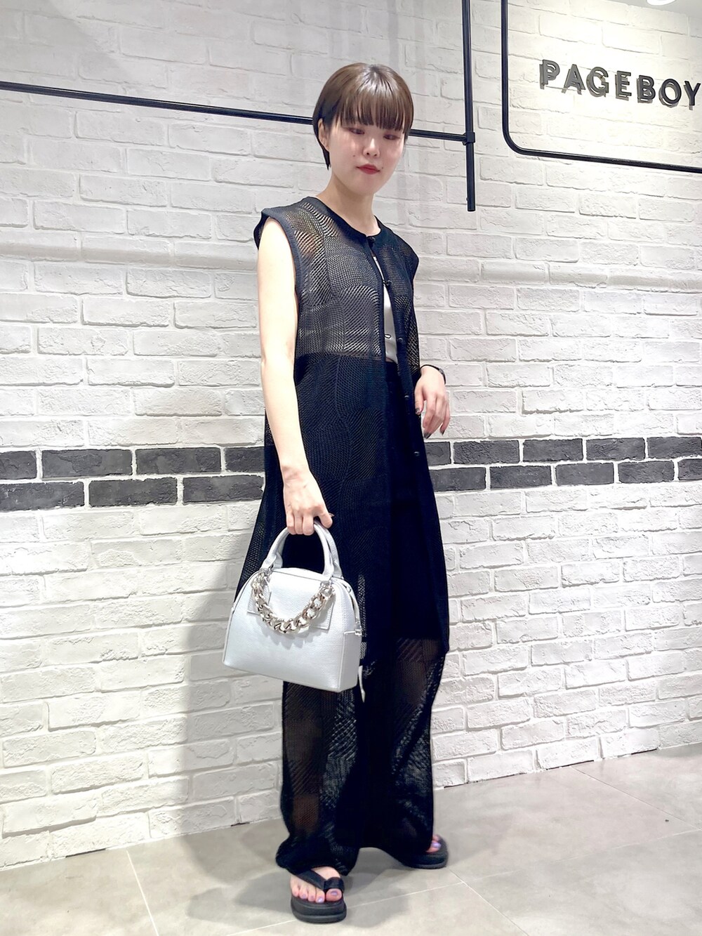 シルバー系のショルダーバッグ、ブラック系のその他パンツ、ブラック系のサンダルを着用したレディースの夏コーディネートの2枚目の写真