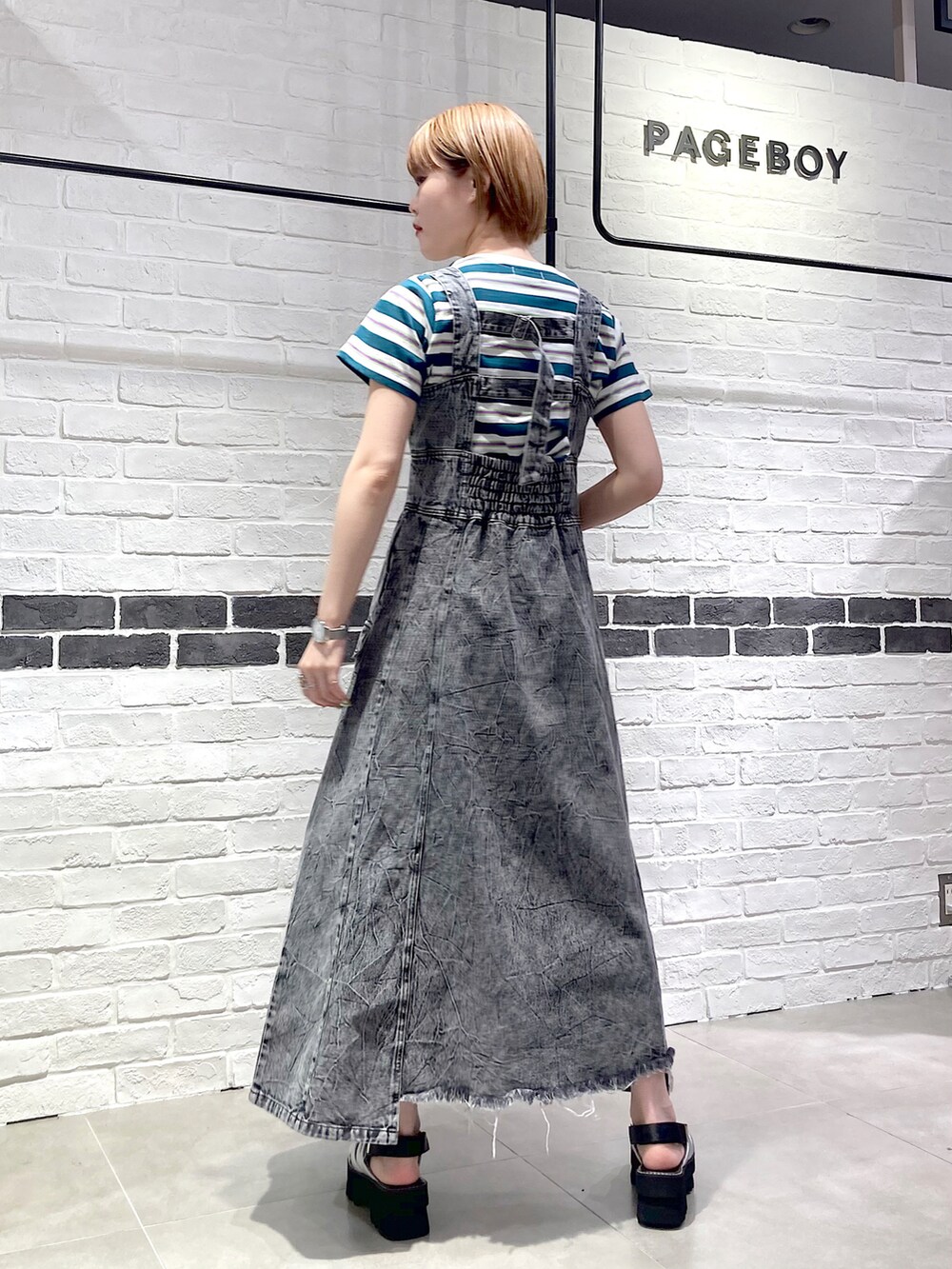 ブラック系のワンピース、グリーン系のTシャツ/カットソー、シルバー系のサンダルを着用したレディースの春コーディネートの4枚目の写真