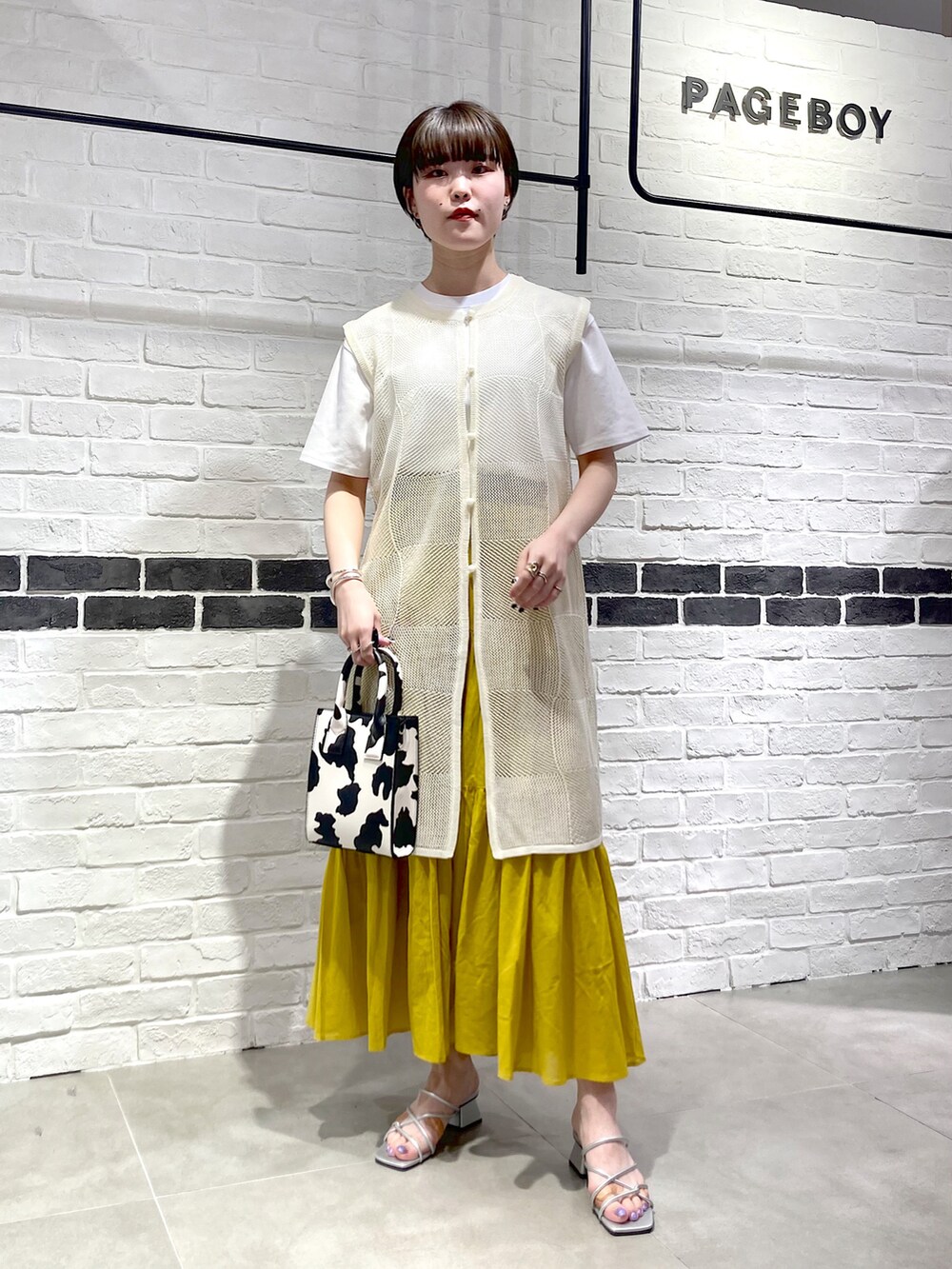 シルバー系のサンダル、ホワイト系のショルダーバッグ、ホワイト系のカーディガン/ボレロを着用したレディースの夏コーディネートの2枚目の写真