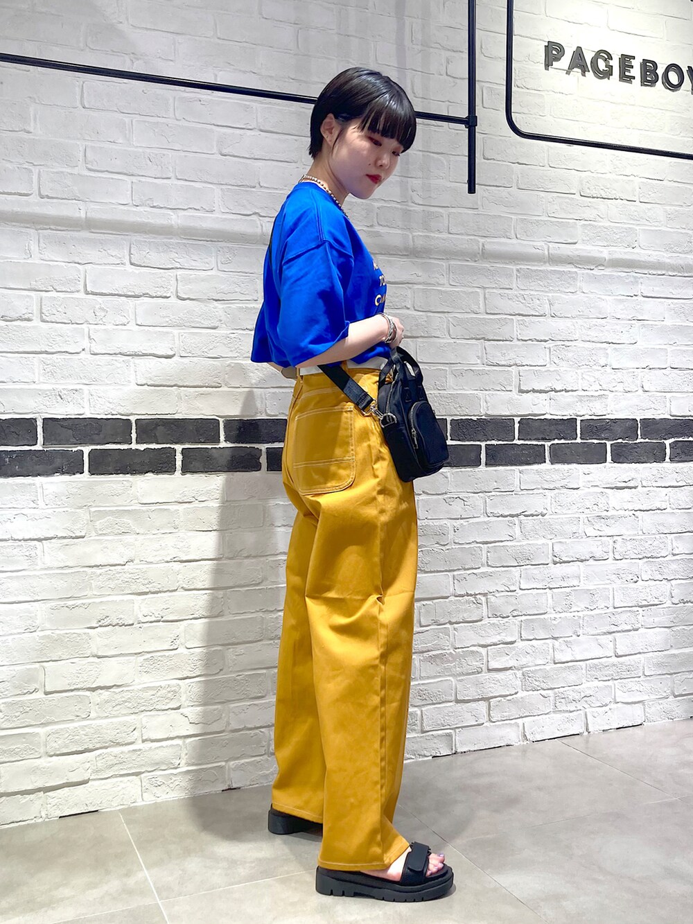 ブルー系のTシャツ/カットソー、ブラック系のショルダーバッグ、イエロー系のその他パンツを着用したレディースの夏コーディネートの4枚目の写真