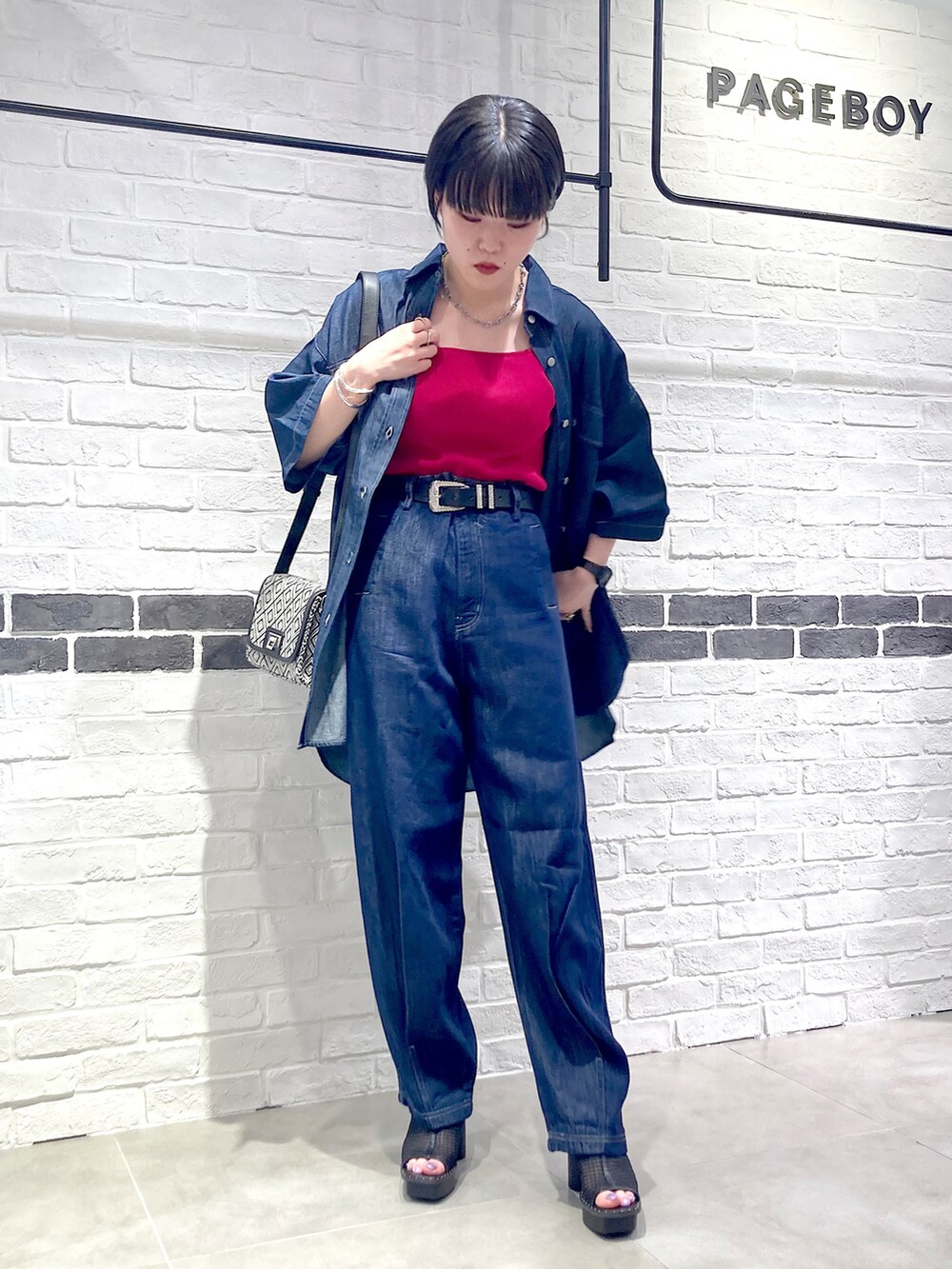 ブルー系のデニムパンツ、ブラック系のサンダル、ブルー系のシャツ/ブラウスを着用したレディースの夏コーディネートの2枚目の写真