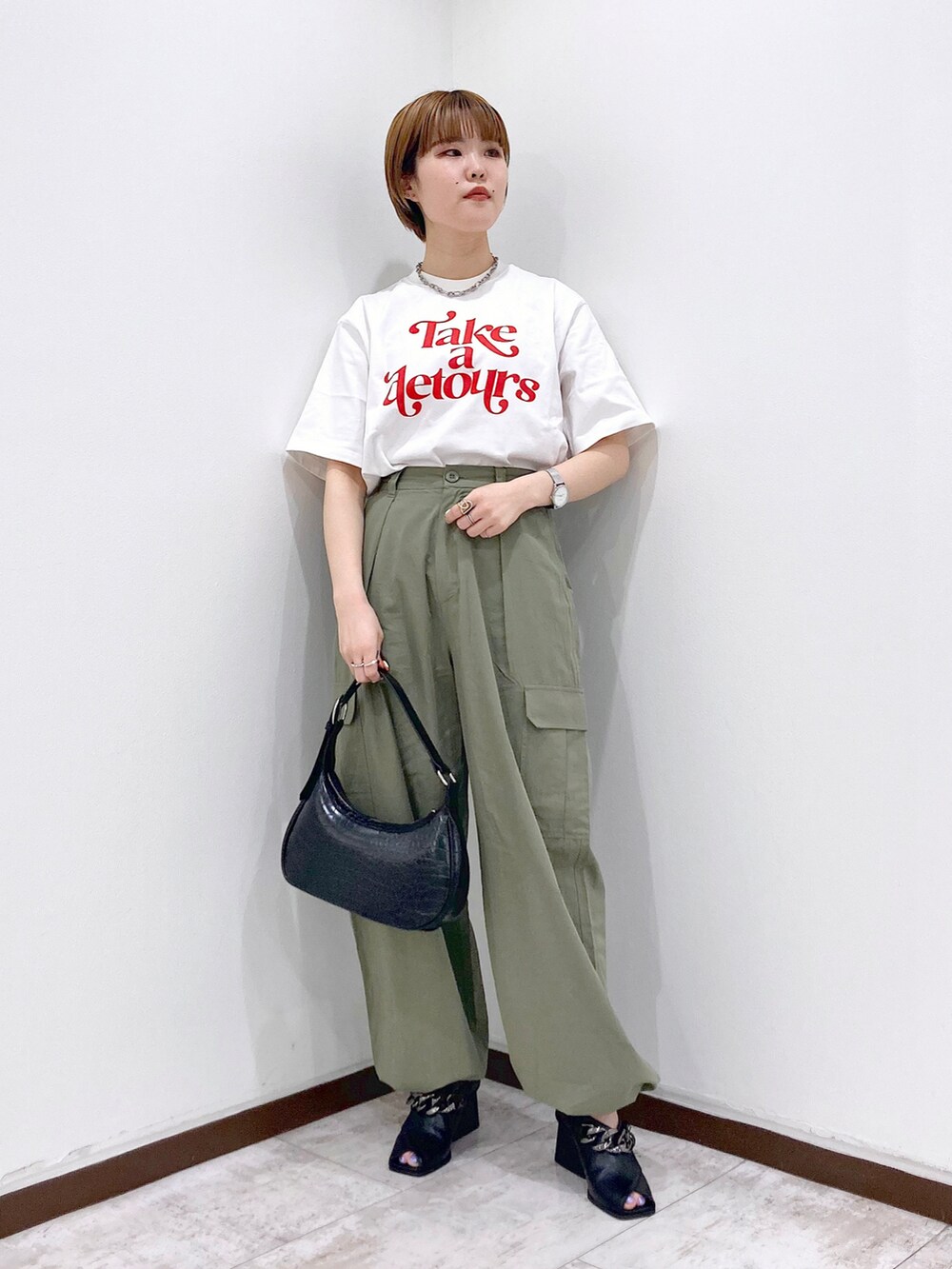 ホワイト系のTシャツ/カットソー、レッド系のカーディガン/ボレロ、グリーン系のカーゴパンツを着用したレディースの春コーディネートの4枚目の写真