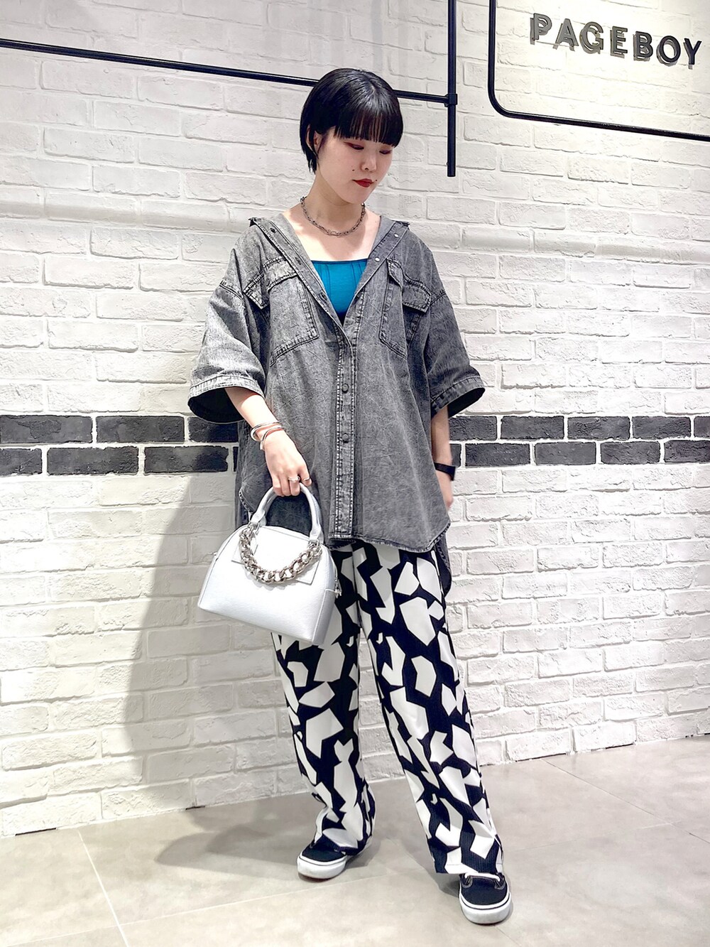 シルバー系のショルダーバッグ、ブラック系のシャツ/ブラウス、グリーン系のタンクトップを着用したレディースの夏コーディネートの2枚目の写真