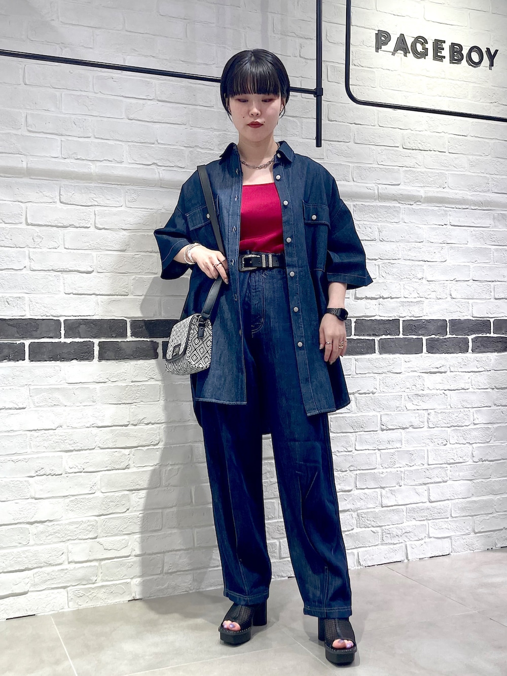 ブルー系のデニムパンツ、ブラック系のサンダル、ブルー系のシャツ/ブラウスを着用したレディースの夏コーディネートの3枚目の写真