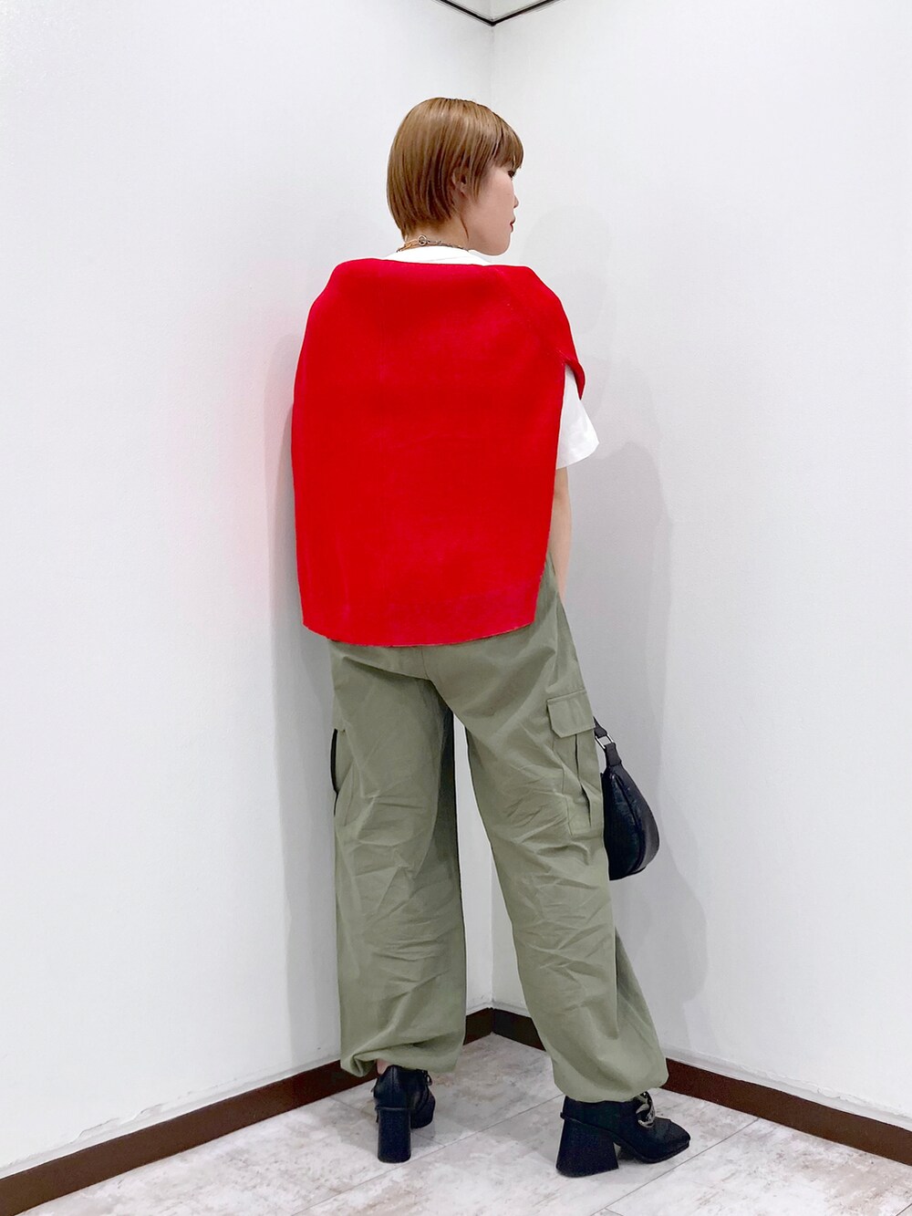 ホワイト系のTシャツ/カットソー、レッド系のカーディガン/ボレロ、グリーン系のカーゴパンツを着用したレディースの春コーディネートの3枚目の写真