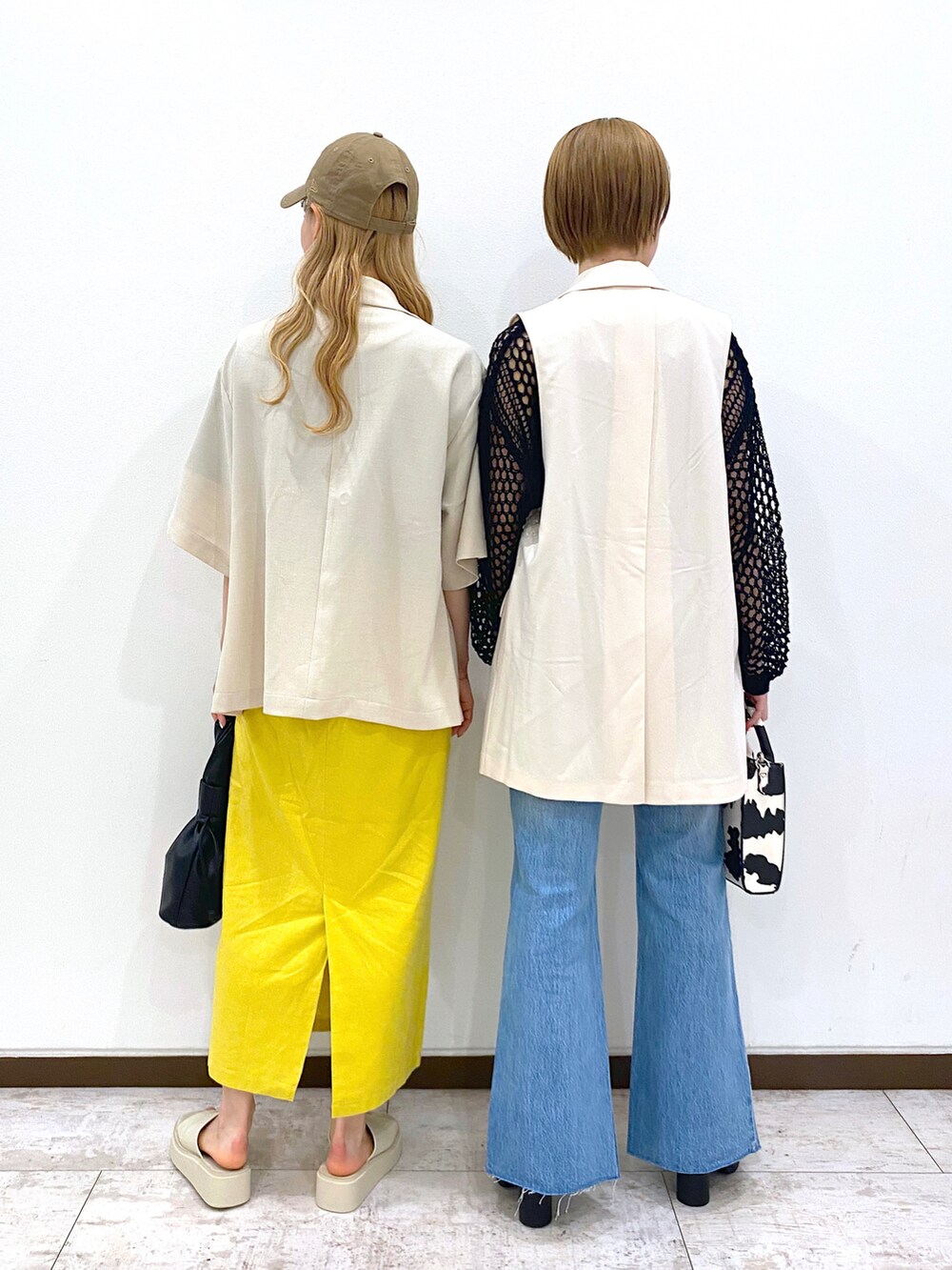 ホワイト系のその他アウター、ブラック系のニット/セーター、ホワイト系のショルダーバッグを着用したレディースの春コーディネートの3枚目の写真