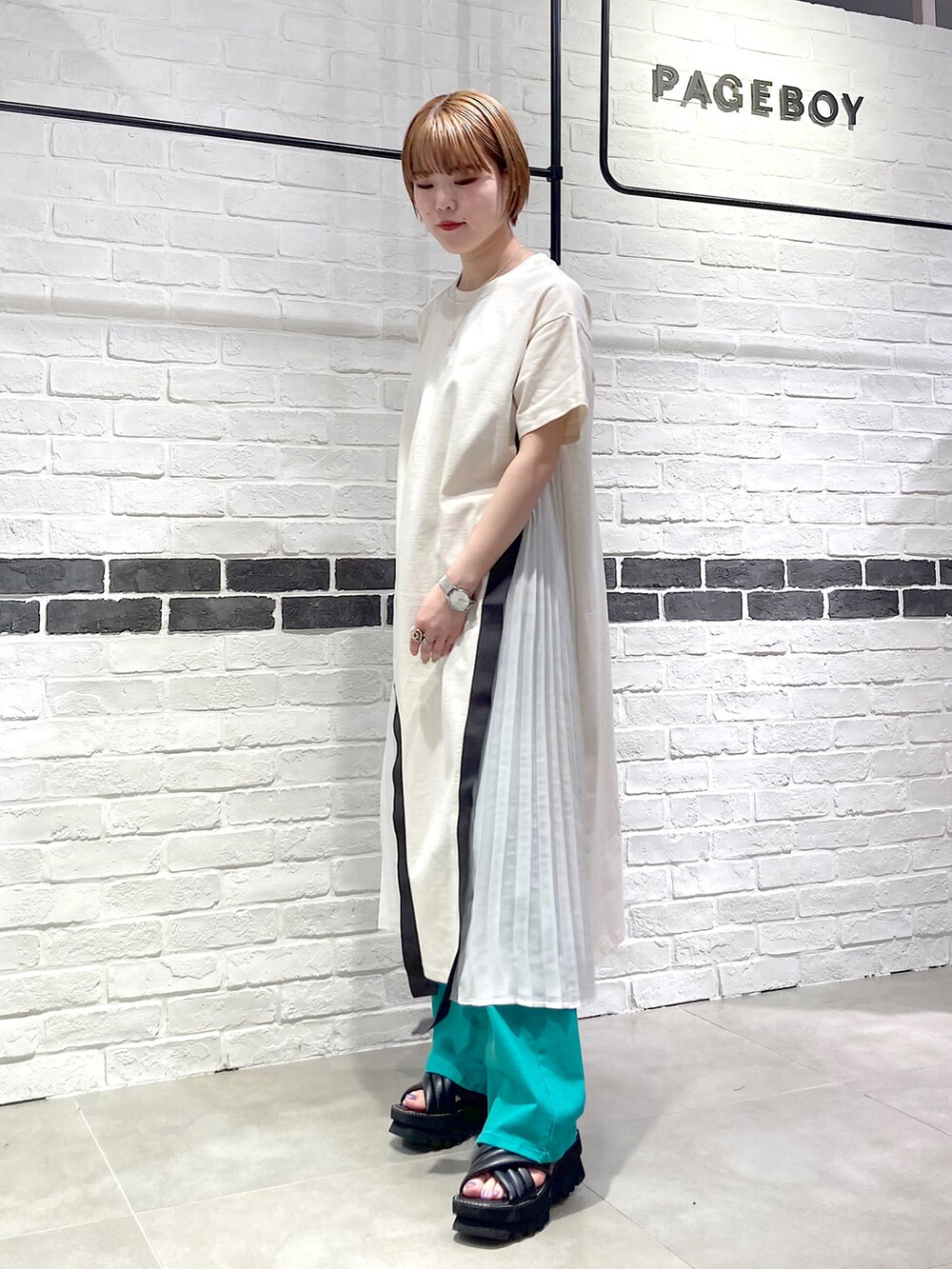 その他のショルダーバッグ、ホワイト系のワンピース、グリーン系のデニムパンツを着用したレディースの春コーディネートの3枚目の写真