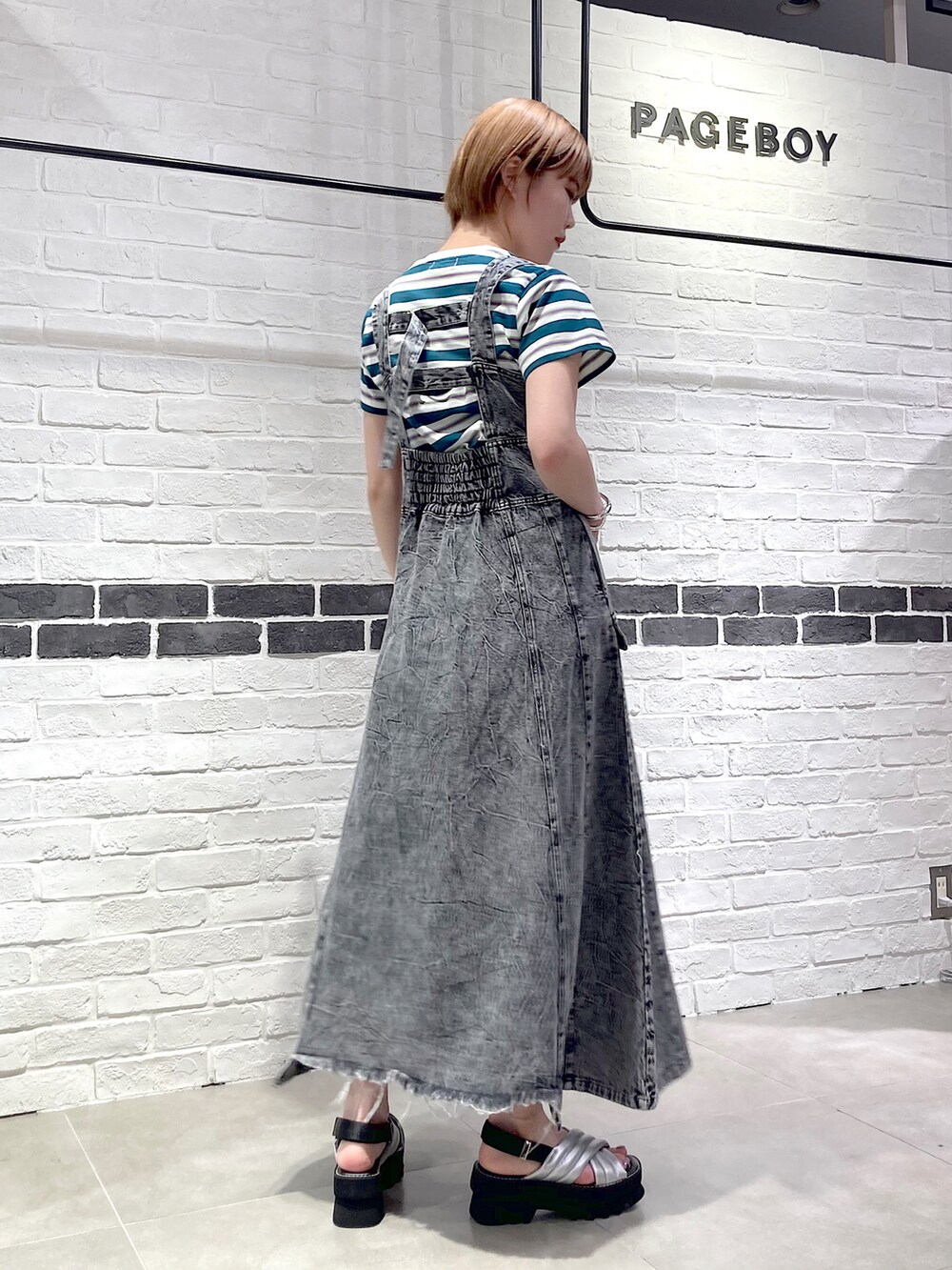 ブラック系のワンピース、グリーン系のTシャツ/カットソー、シルバー系のサンダルを着用したレディースの春コーディネートの3枚目の写真