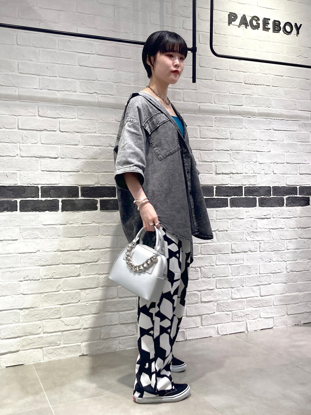 シルバー系のショルダーバッグ、ブラック系のシャツ/ブラウス、グリーン系のタンクトップを着用したレディースの夏コーディネートの3枚目の写真