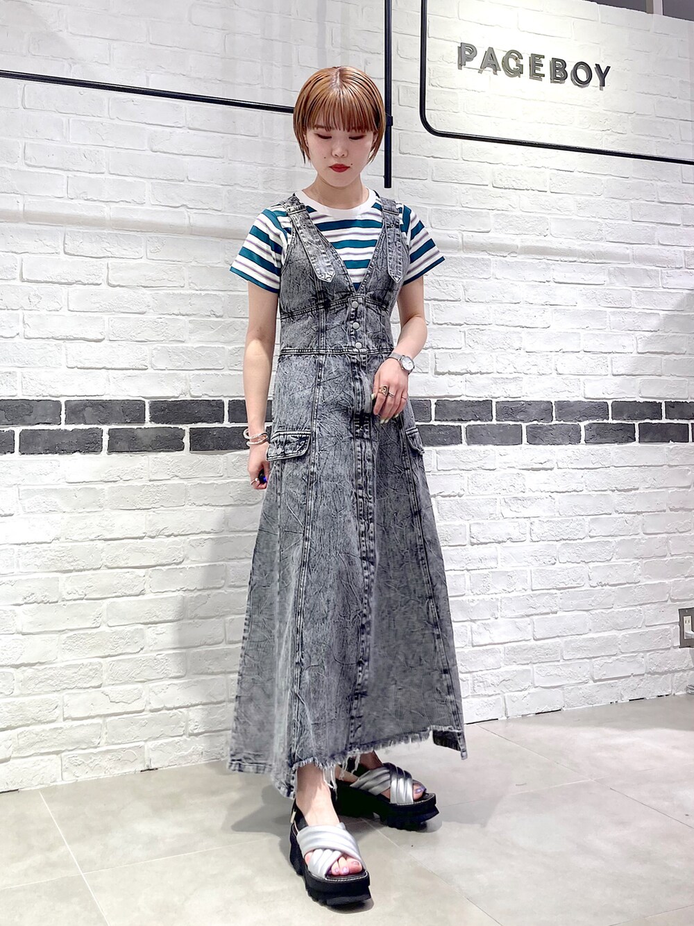 ブラック系のワンピース、グリーン系のTシャツ/カットソー、シルバー系のサンダルを着用したレディースの春コーディネートの5枚目の写真