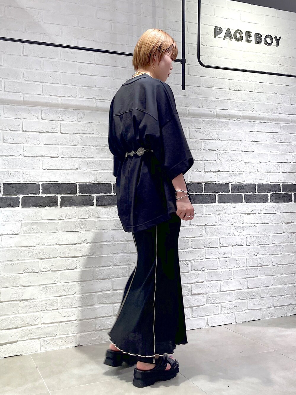 ブラック系のTシャツ/カットソー、ブラック系のスカート、ブラック系のサンダルを着用したレディースの春コーディネートの4枚目の写真