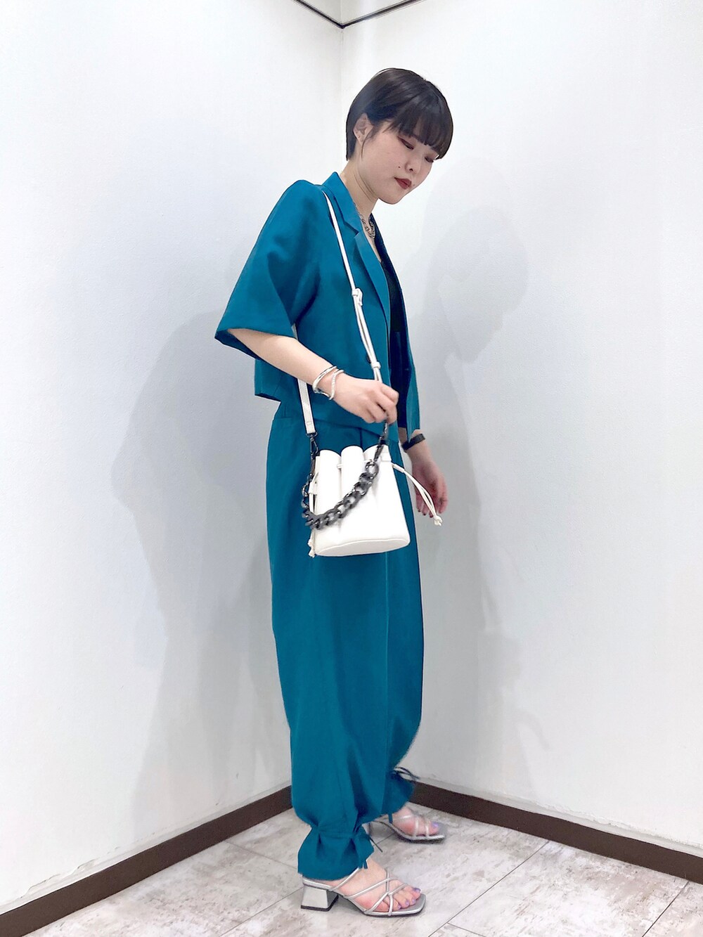 ブラック系のタンクトップ、ブルー系のテーラードジャケット、ブルー系のスラックスを着用したレディースの夏コーディネートの3枚目の写真
