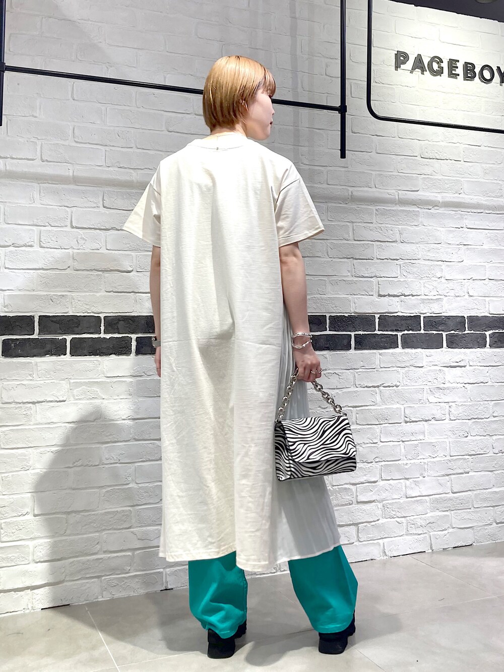 その他のショルダーバッグ、ホワイト系のワンピース、グリーン系のデニムパンツを着用したレディースの春コーディネートの4枚目の写真