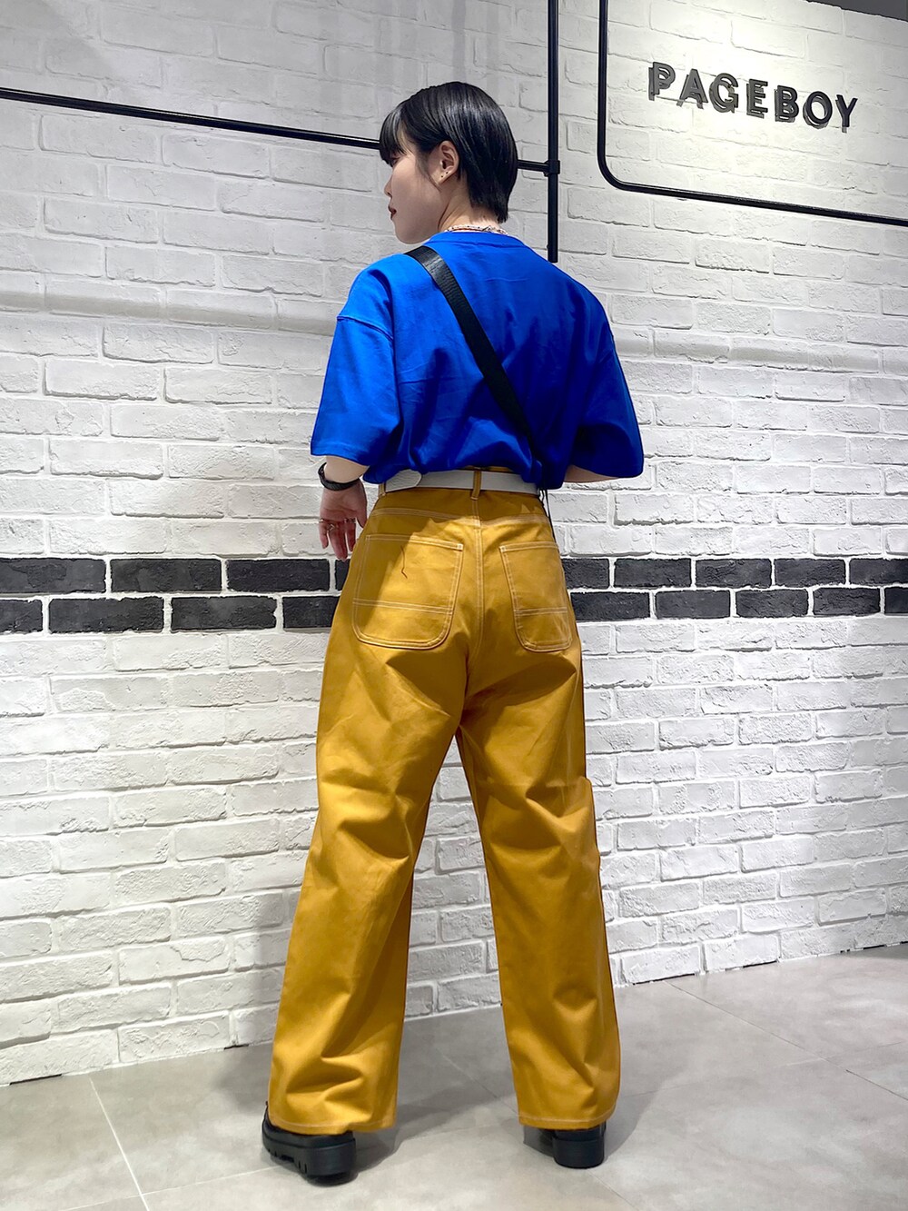 ブルー系のTシャツ/カットソー、ブラック系のショルダーバッグ、イエロー系のその他パンツを着用したレディースの夏コーディネートの5枚目の写真