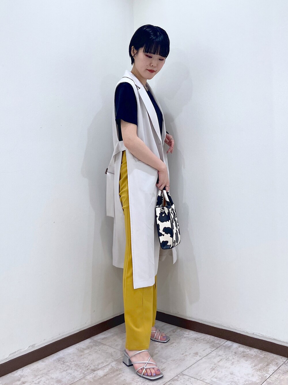 ブラック系のTシャツ/カットソー、ベージュ系のその他アウター、イエロー系のスラックスを着用したレディースの夏コーディネートの3枚目の写真