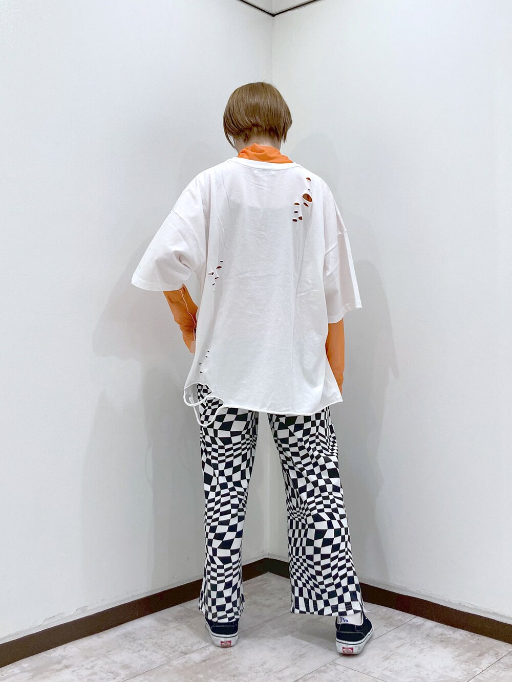 ホワイト系のTシャツ/カットソー、オレンジ系のTシャツ/カットソー、ホワイト系のスラックスを着用したレディースの春コーディネートの4枚目の写真