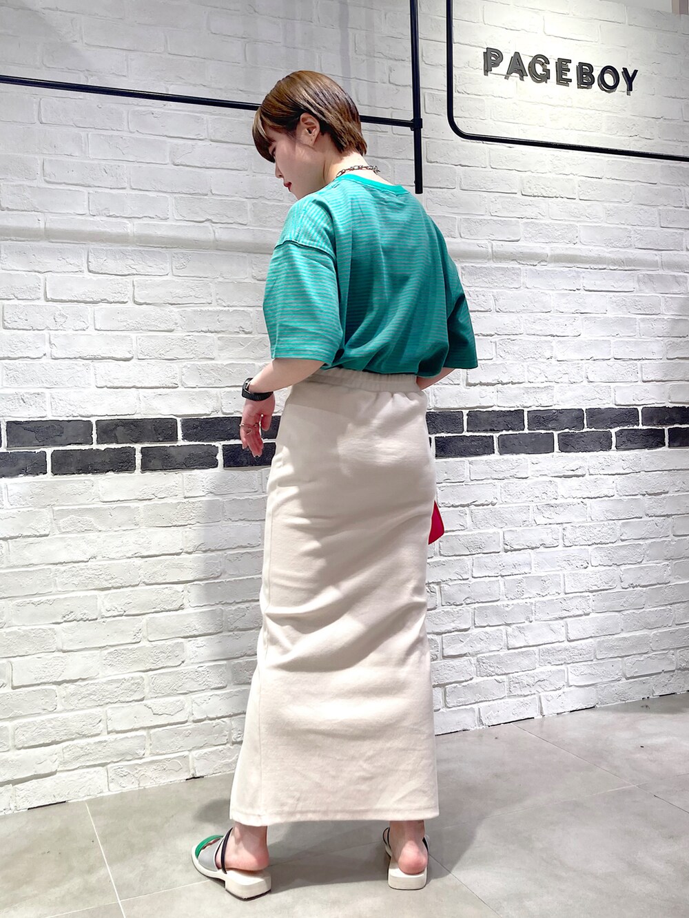 グリーン系のTシャツ/カットソー、ピンク系のショルダーバッグ、ホワイト系のスカートを着用したレディースの夏コーディネートの3枚目の写真