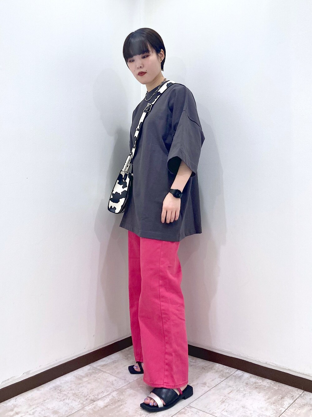 ピンク系のデニムパンツ、グレー系のTシャツ/カットソー、ホワイト系のショルダーバッグを着用したレディースの夏コーディネートの3枚目の写真