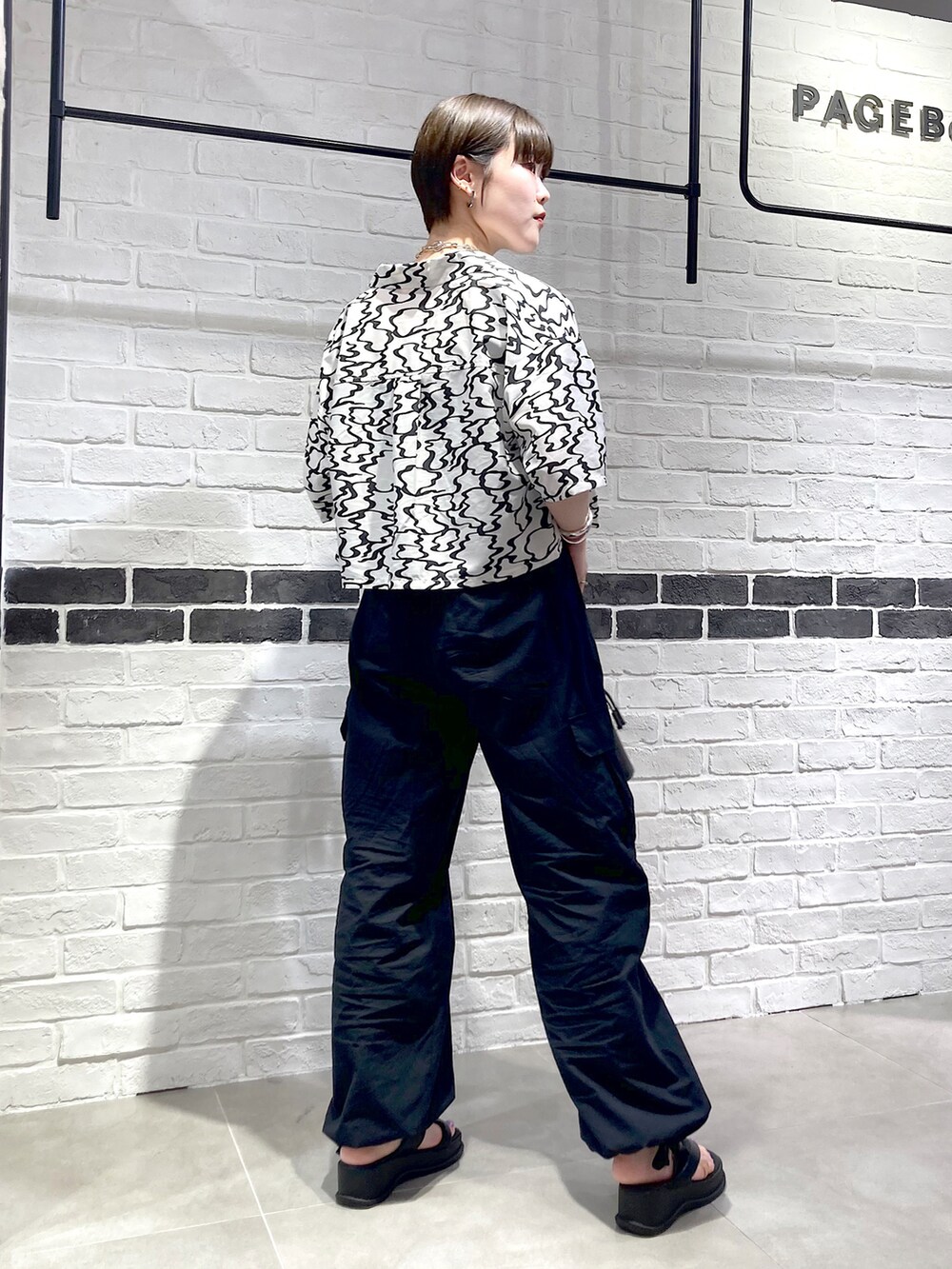 ブラック系のシャツ/ブラウス、グリーン系のタンクトップ、ブラック系のショルダーバッグを着用したレディースの夏コーディネートの4枚目の写真