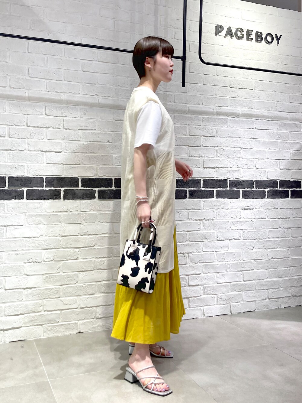 シルバー系のサンダル、ホワイト系のショルダーバッグ、ホワイト系のカーディガン/ボレロを着用したレディースの夏コーディネートの3枚目の写真