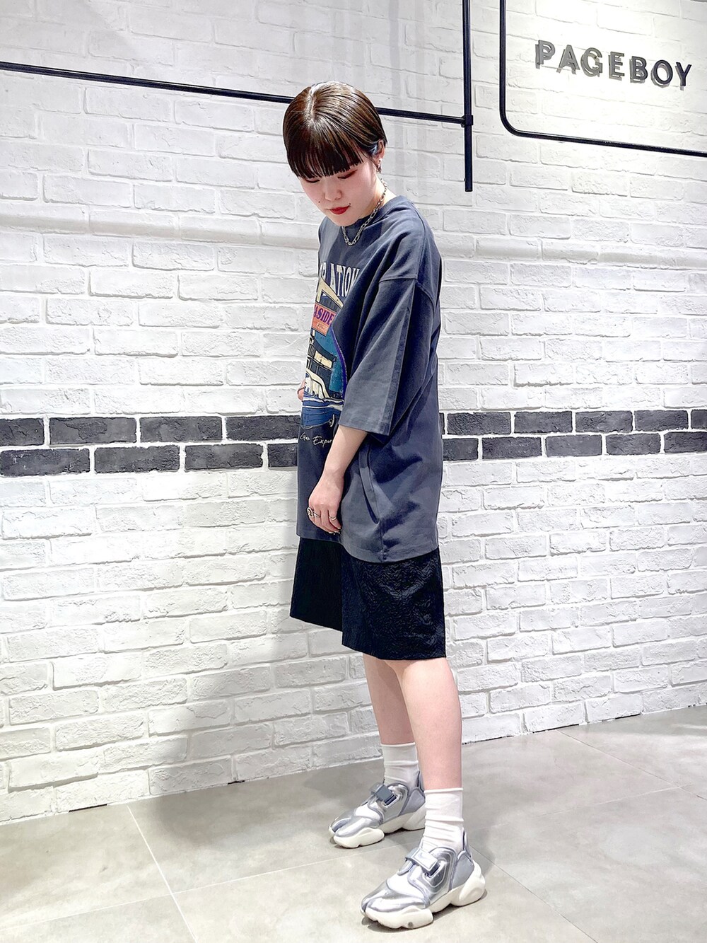 グレー系のTシャツ/カットソー、ブラック系のその他パンツ、シルバー系のスニーカーを着用したレディースの春コーディネートの2枚目の写真