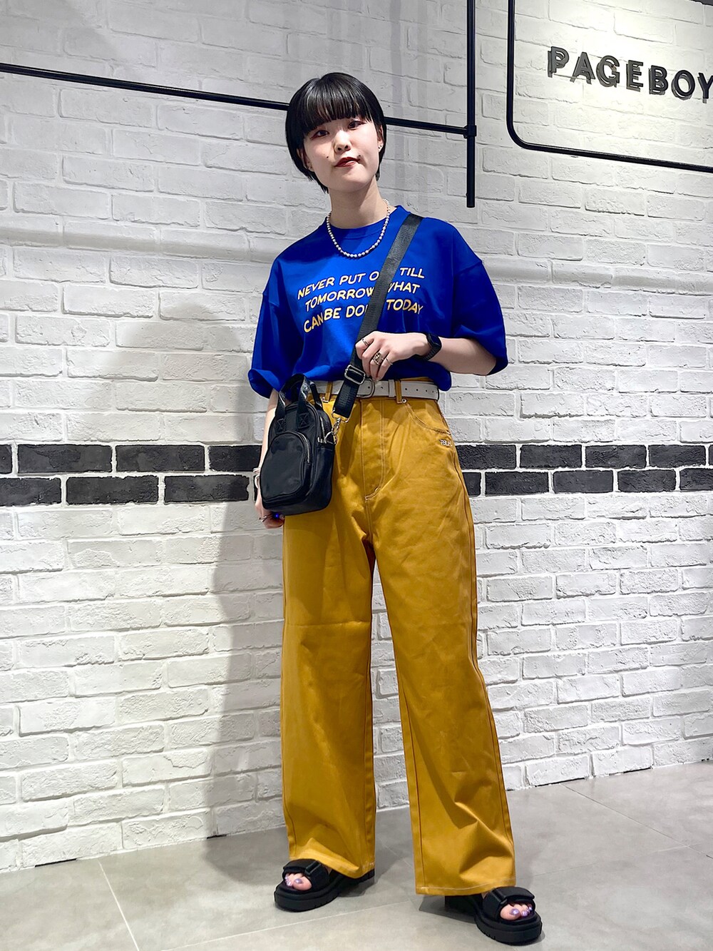 ブルー系のTシャツ/カットソー、ブラック系のショルダーバッグ、イエロー系のその他パンツを着用したレディースの夏コーディネートの2枚目の写真