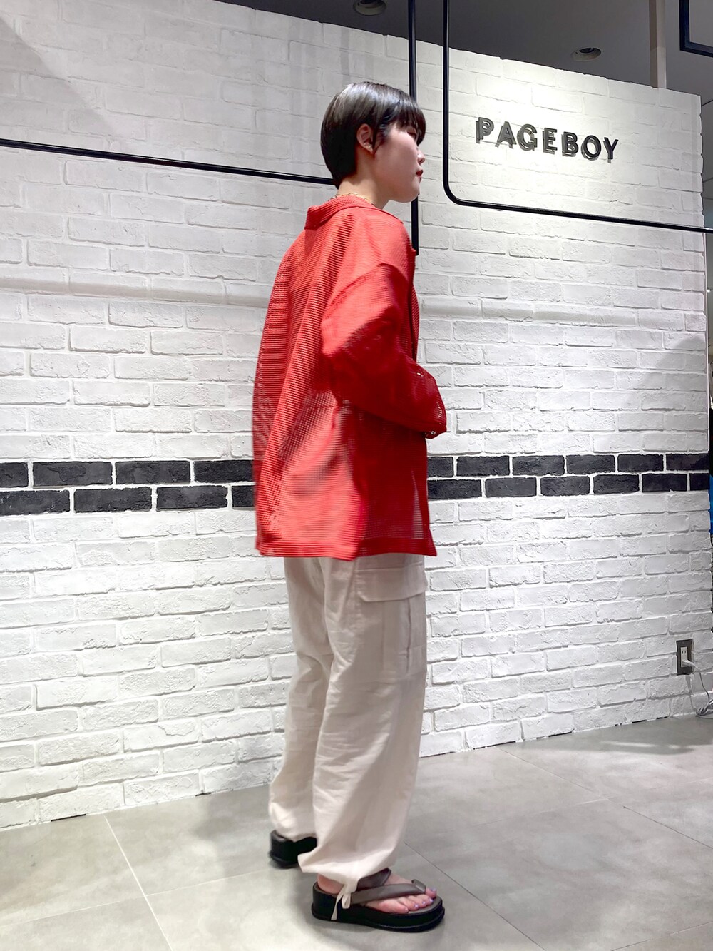 オレンジ系のテーラードジャケット、ブラウン系のタンクトップ、ホワイト系のカーゴパンツを着用したレディースの春コーディネートの4枚目の写真