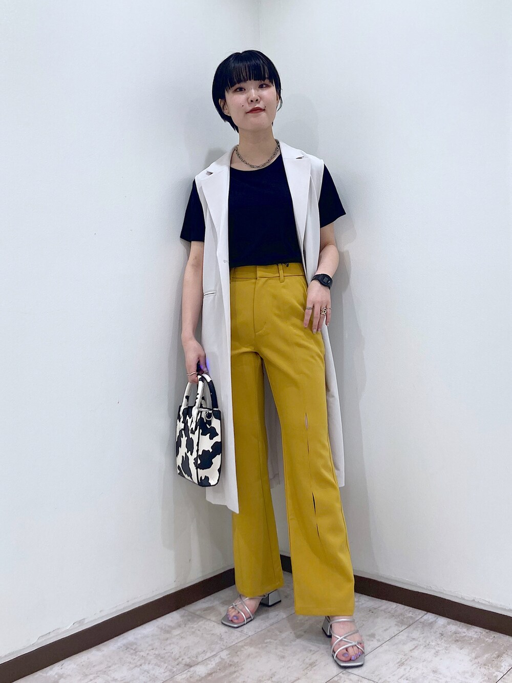 ブラック系のTシャツ/カットソー、ベージュ系のその他アウター、イエロー系のスラックスを着用したレディースの夏コーディネートの2枚目の写真