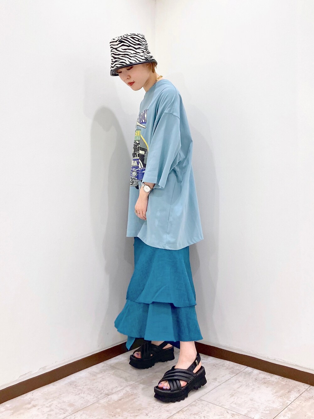 ブルー系のTシャツ/カットソー、ブラック系のショルダーバッグ、ブルー系のスカートを着用したレディースの春コーディネートの4枚目の写真