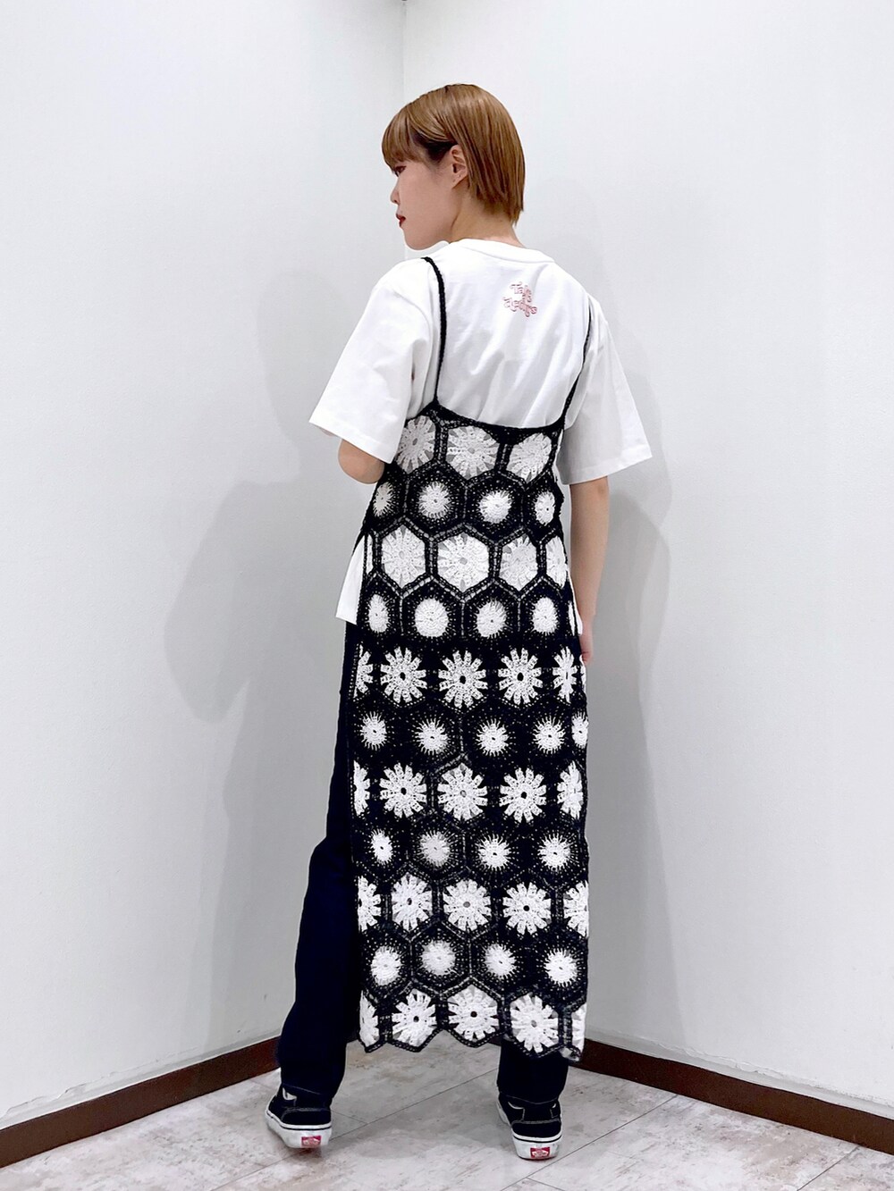 ブラック系のワンピース、ホワイト系のTシャツ/カットソー、ブルー系のデニムパンツを着用したレディースの春コーディネートの3枚目の写真