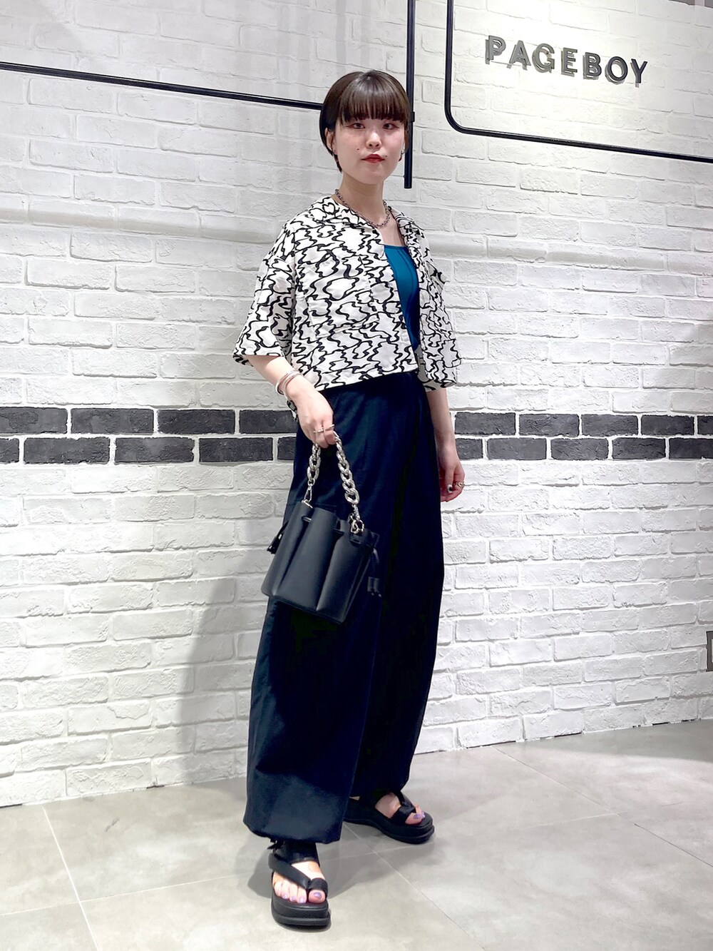 ブラック系のシャツ/ブラウス、グリーン系のタンクトップ、ブラック系のショルダーバッグを着用したレディースの夏コーディネートの3枚目の写真