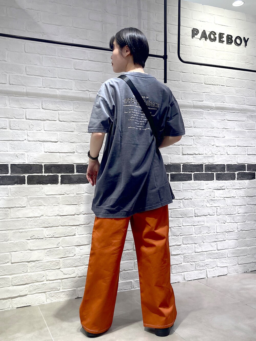 オレンジ系のその他パンツ、ブラック系のサンダル、グレー系のTシャツ/カットソーを着用したレディースの夏コーディネートの4枚目の写真