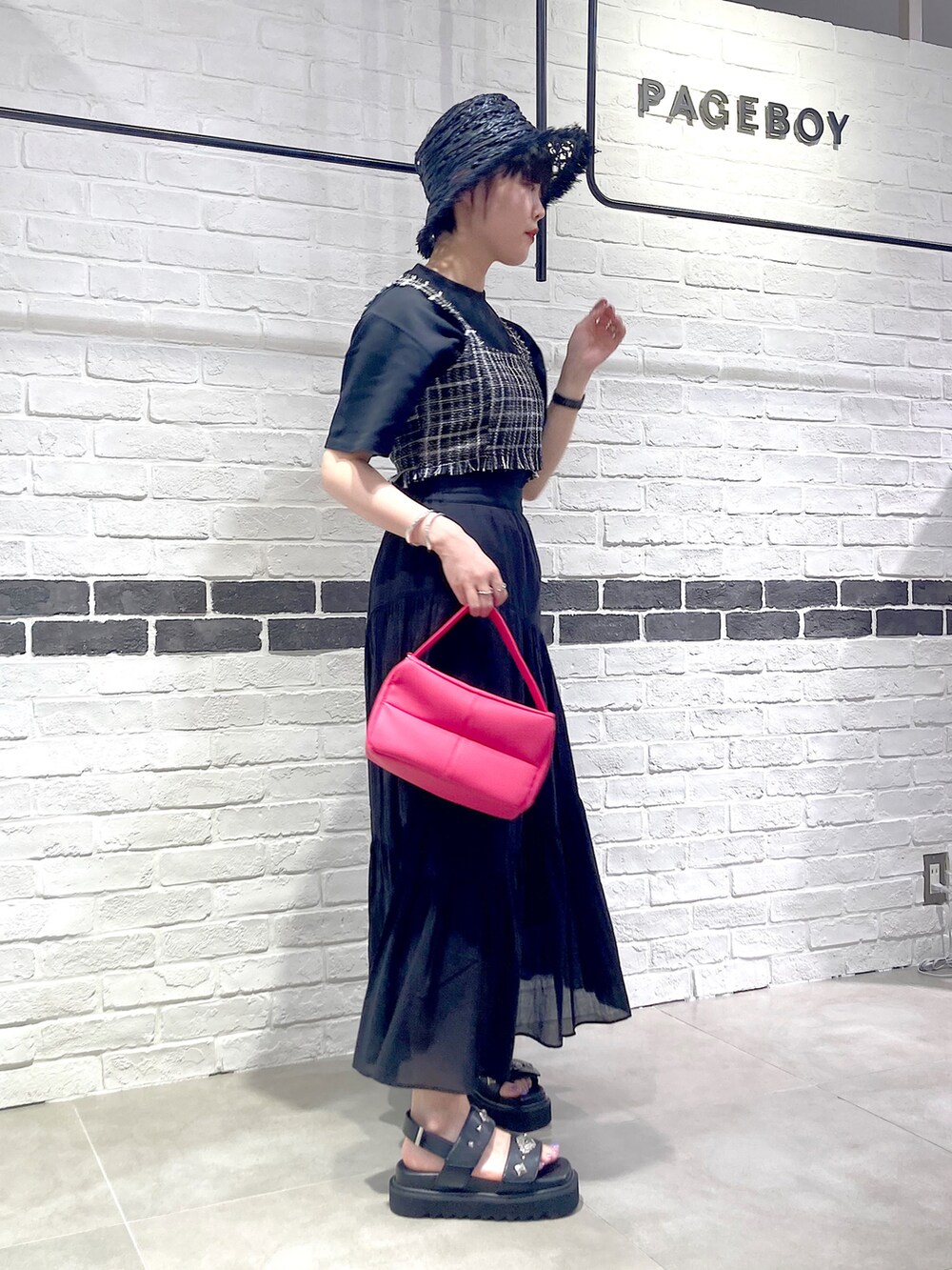 ピンク系のショルダーバッグ、ブラック系のその他トップス、ブラック系のTシャツ/カットソーを着用したレディースの夏コーディネートの3枚目の写真