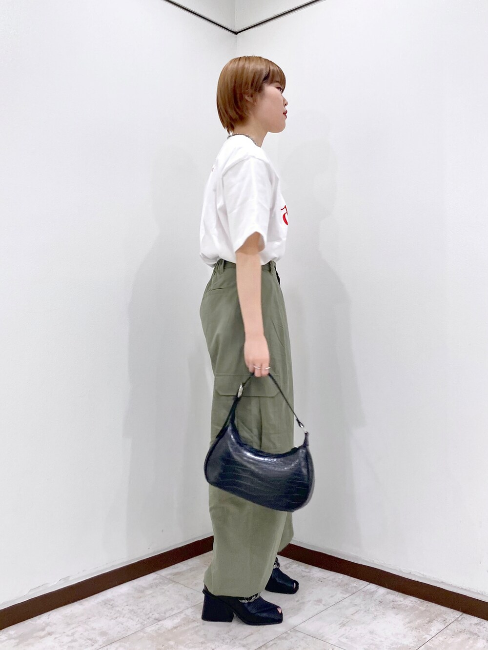 ホワイト系のTシャツ/カットソー、レッド系のカーディガン/ボレロ、グリーン系のカーゴパンツを着用したレディースの春コーディネートの5枚目の写真