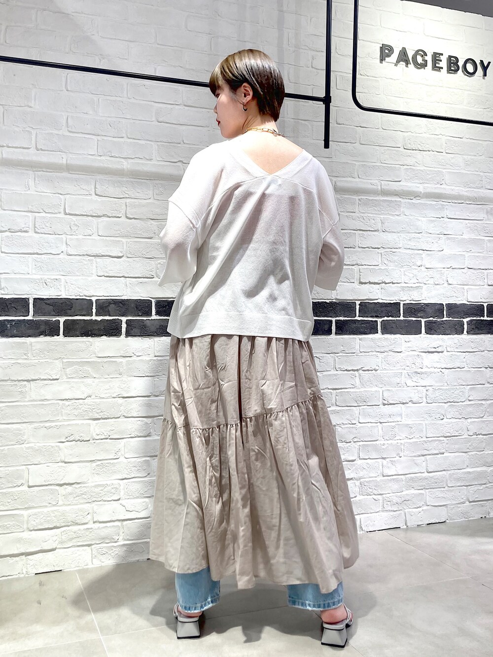 ベージュ系のワンピース、ホワイト系のカーディガン/ボレロ、オレンジ系のタンクトップを着用したレディースの夏コーディネートの5枚目の写真