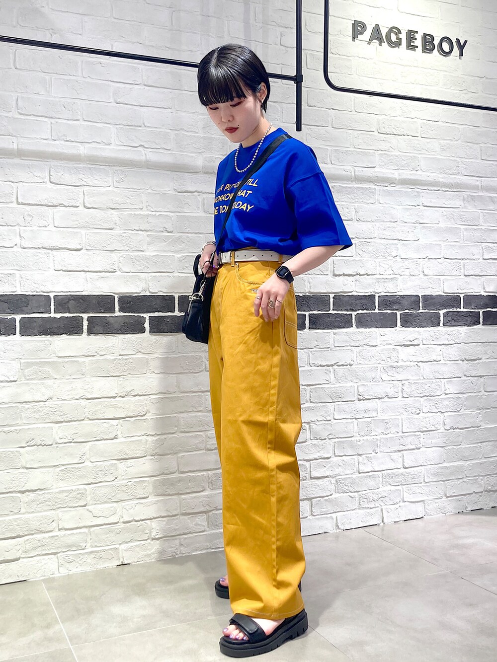 ブルー系のTシャツ/カットソー、ブラック系のショルダーバッグ、イエロー系のその他パンツを着用したレディースの夏コーディネートの3枚目の写真