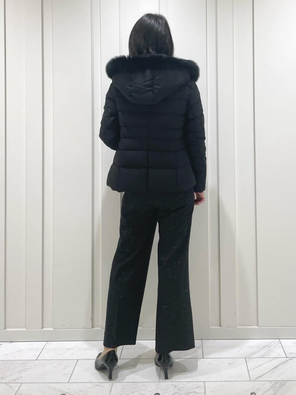 ブラック系のその他パンツ、ベージュ系のニット/セーター、ブラック系のダウンジャケット/コートを着用したレディースの冬コーディネートの3枚目の写真