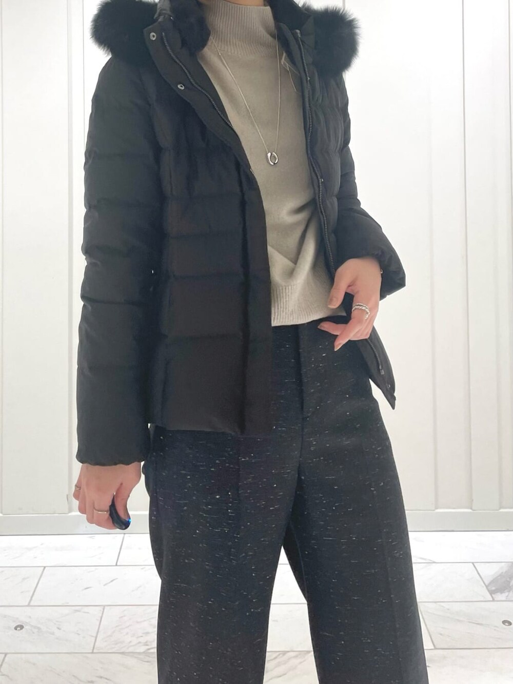 ブラック系のその他パンツ、ベージュ系のニット/セーター、ブラック系のダウンジャケット/コートを着用したレディースの冬コーディネートの5枚目の写真