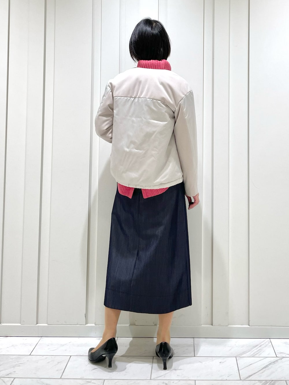 ブルー系のスカート、ピンク系のニット/セーター、ベージュ系のその他アウターを着用したレディースの冬コーディネートの3枚目の写真