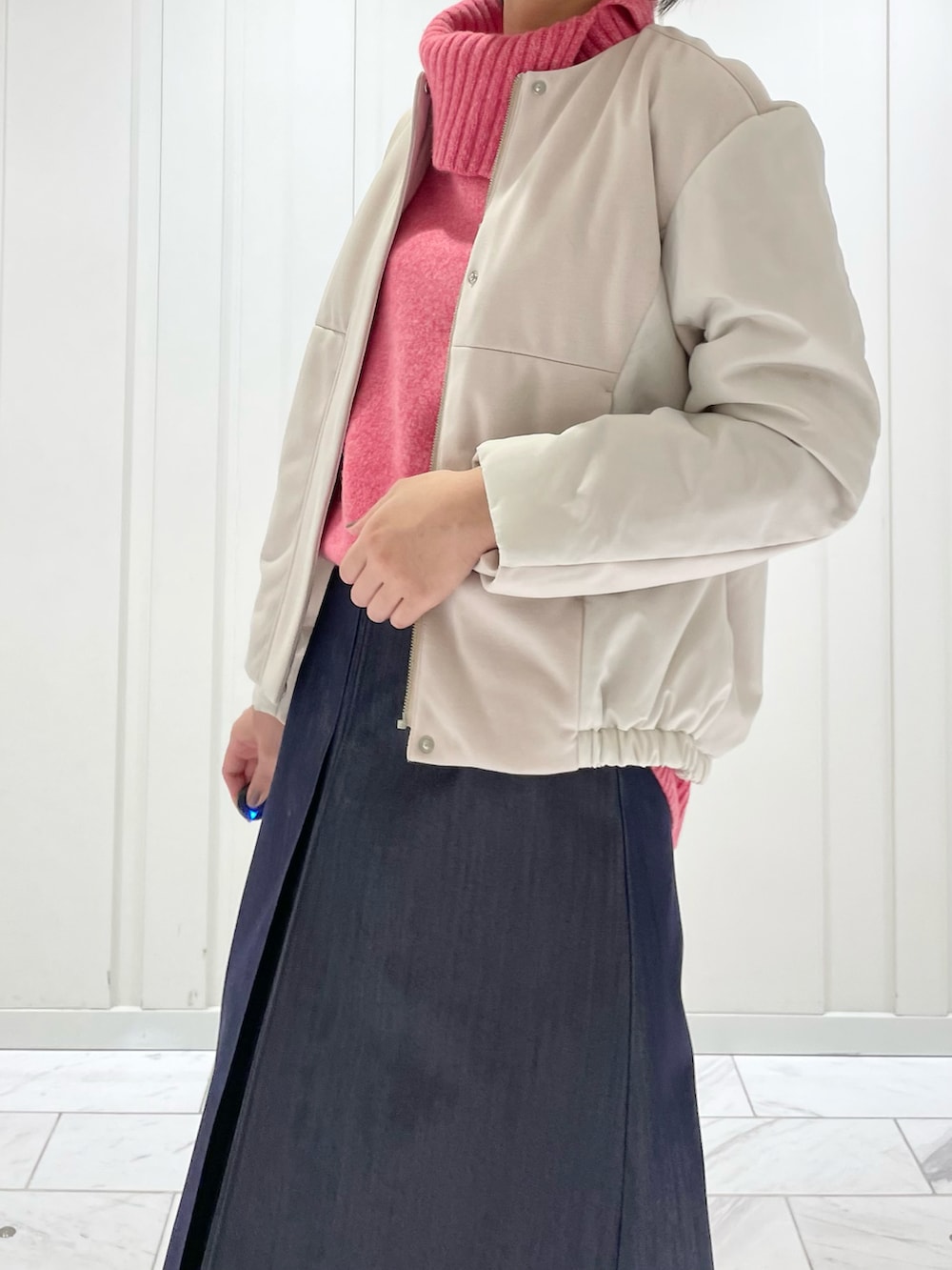 ブルー系のスカート、ピンク系のニット/セーター、ベージュ系のその他アウターを着用したレディースの冬コーディネートの5枚目の写真