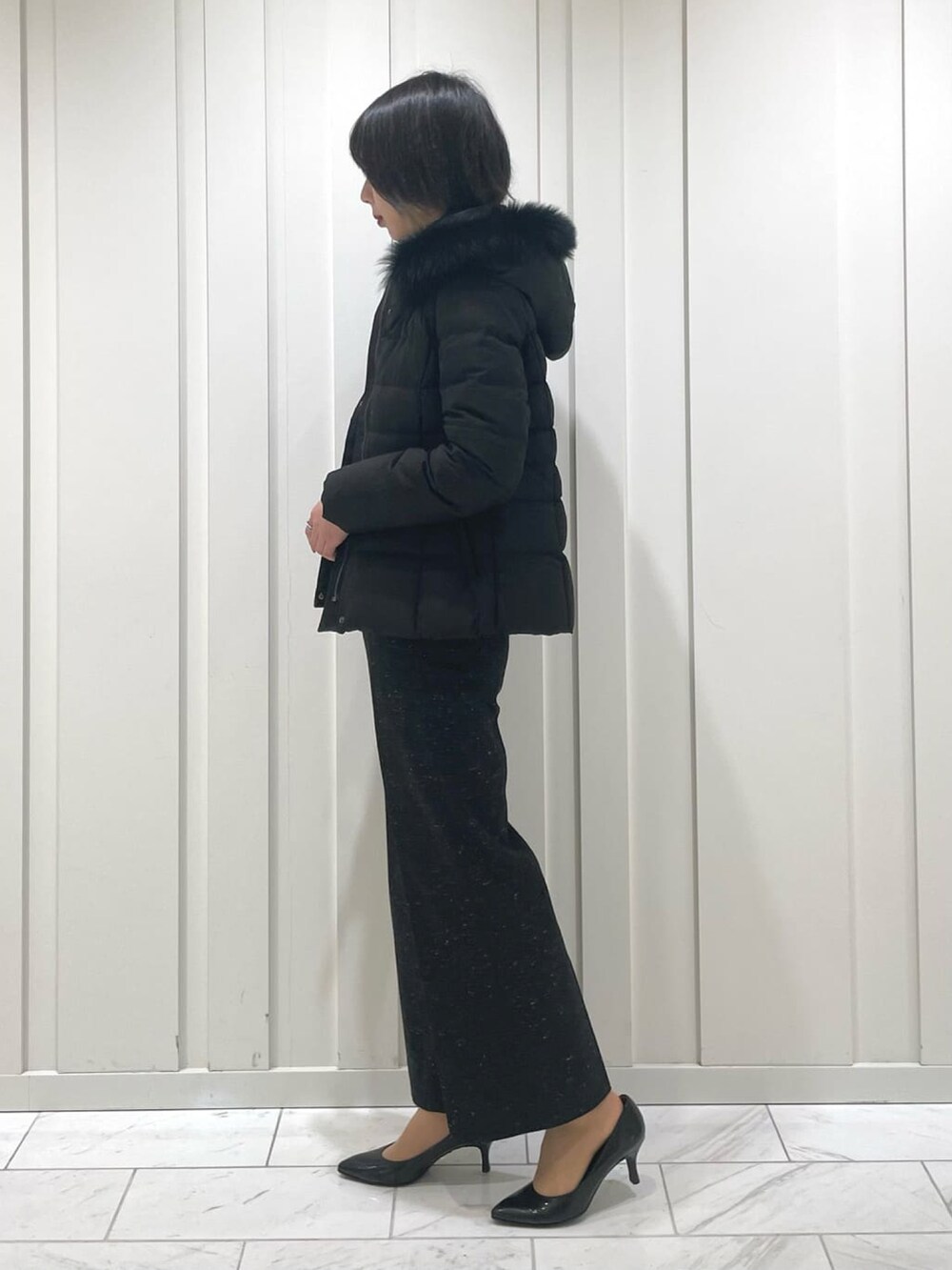 ブラック系のその他パンツ、ベージュ系のニット/セーター、ブラック系のダウンジャケット/コートを着用したレディースの冬コーディネートの2枚目の写真