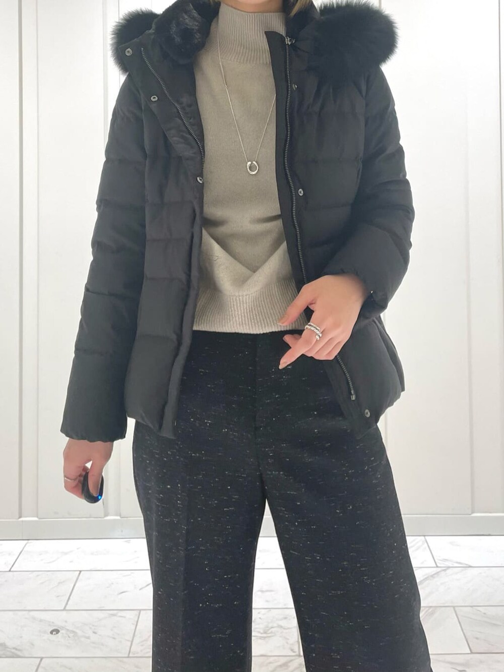 ブラック系のその他パンツ、ベージュ系のニット/セーター、ブラック系のダウンジャケット/コートを着用したレディースの冬コーディネートの4枚目の写真