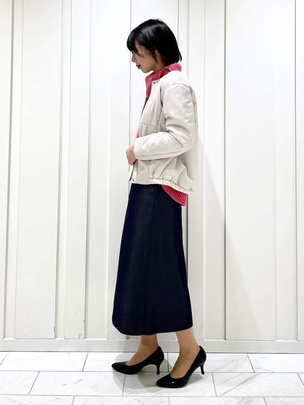 ブルー系のスカート、ピンク系のニット/セーター、ベージュ系のその他アウターを着用したレディースの冬コーディネートの2枚目の写真