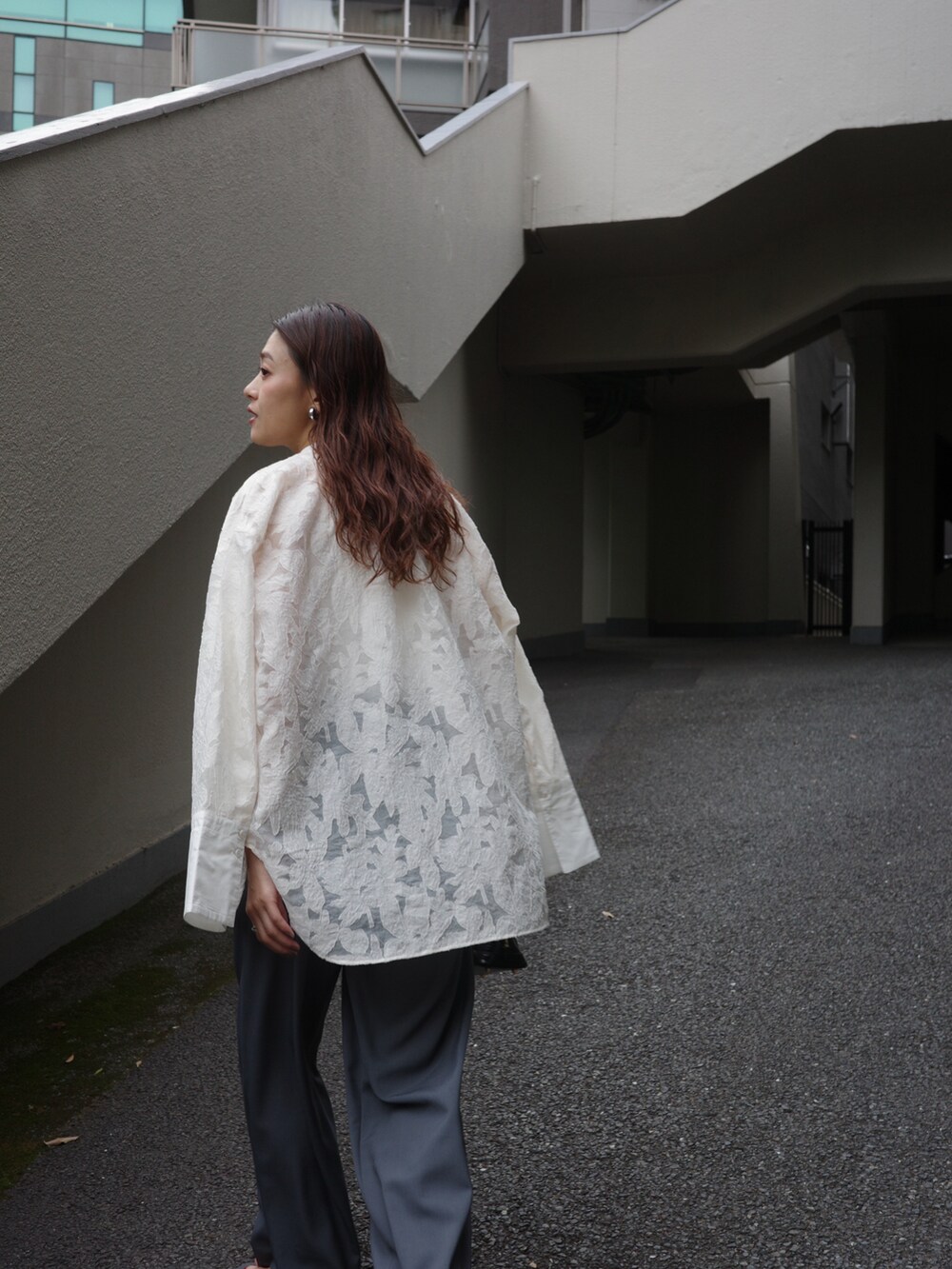 ホワイト系のタンクトップ、ホワイト系のシャツ/ブラウス、グレー系のスラックスを着用したレディースの春コーディネートの2枚目の写真