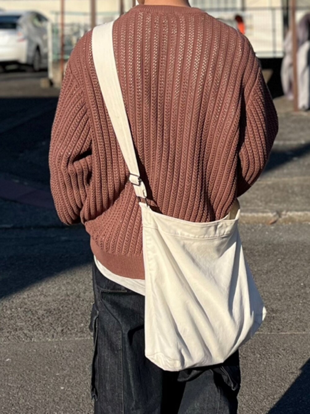 ブラウン系のニット/セーター、ブルー系のデニムパンツ、ブラック系のブーツを着用したメンズの冬コーディネートの5枚目の写真