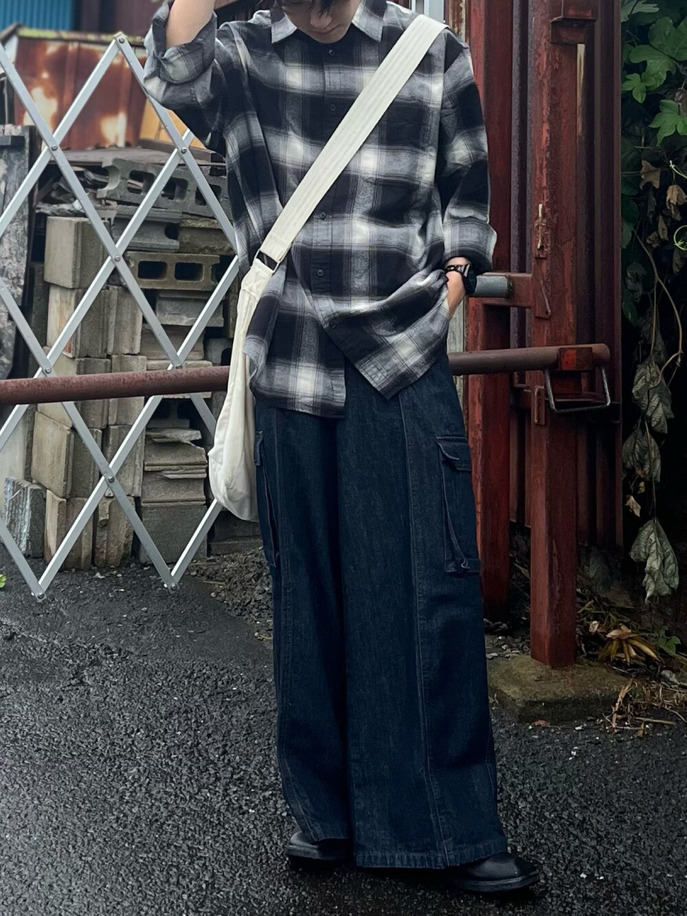 ブラック系のシャツ/ブラウス、ベージュ系のショルダーバッグ、ブルー系のデニムパンツを着用したメンズの秋コーディネートの2枚目の写真